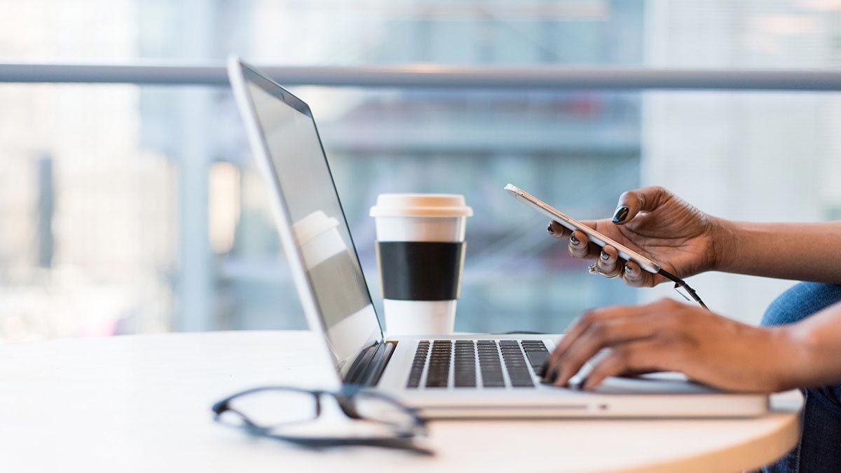 close up of laptop and mobile phone on a table overlooking the city