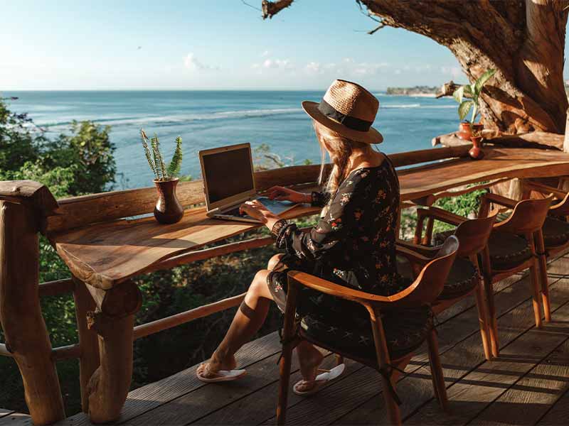 woman working remotely at beach