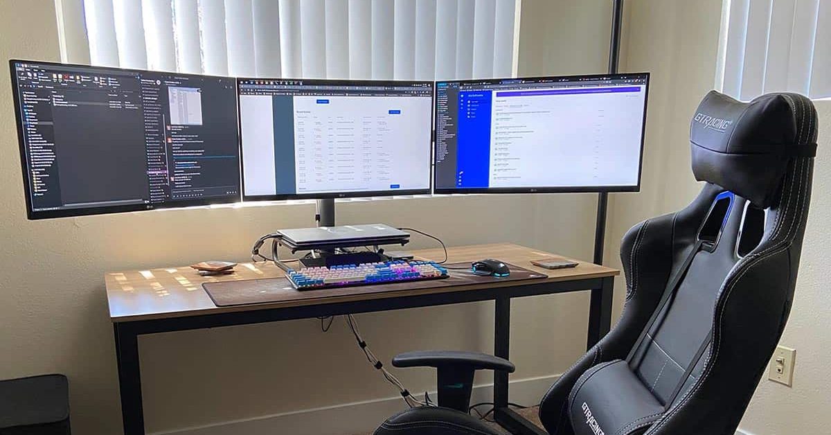 home office with three monitors and gamer chair